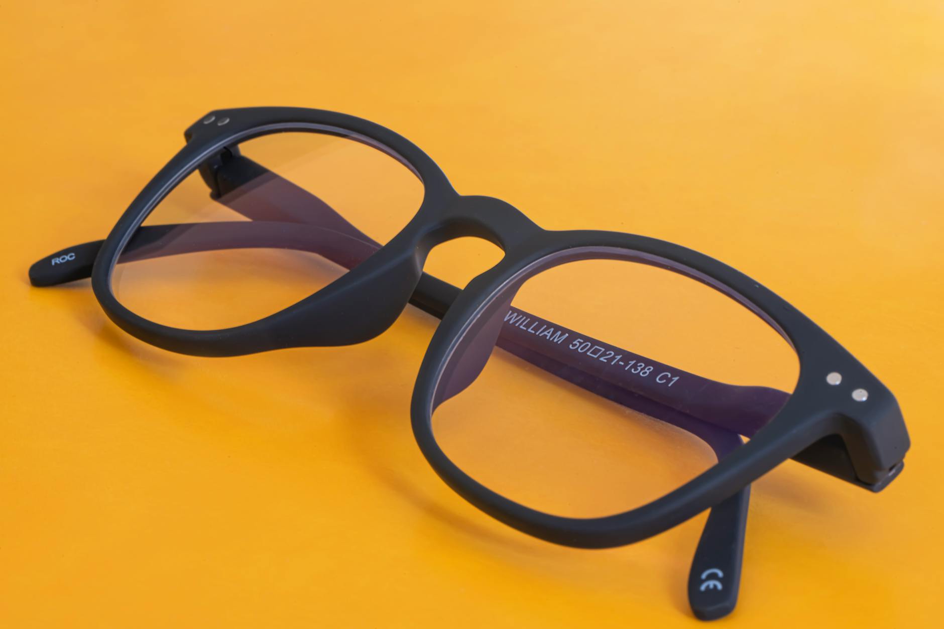 black eyeglasses on vibrant orange background